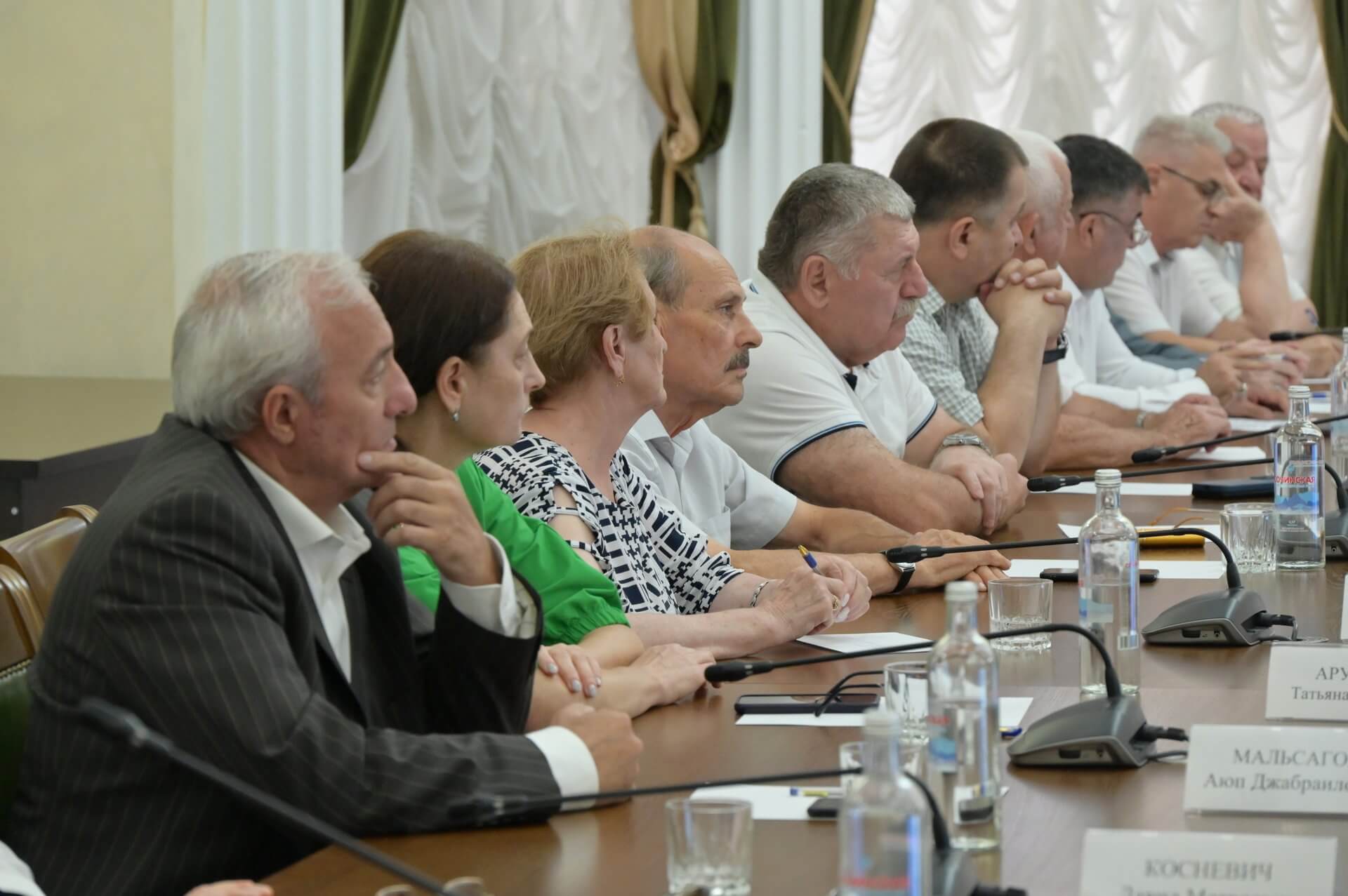На фото проходит встреча местного самоуправления, видно людей сидящих в ряд